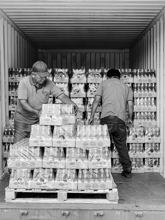 trusted-partner Two workers organize products in a shipping container in Ipoh, Malaysia.