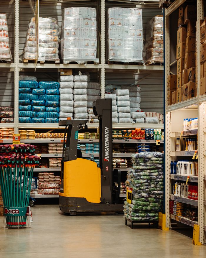 Home A warehouse with stacked goods, shelves, and a forklift in Brazil.